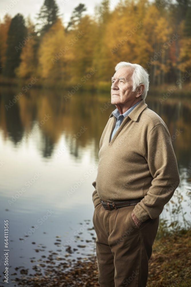 a handsome senior man standing beside a lake in the woods a handsome senior man standing beside a lake in the woods