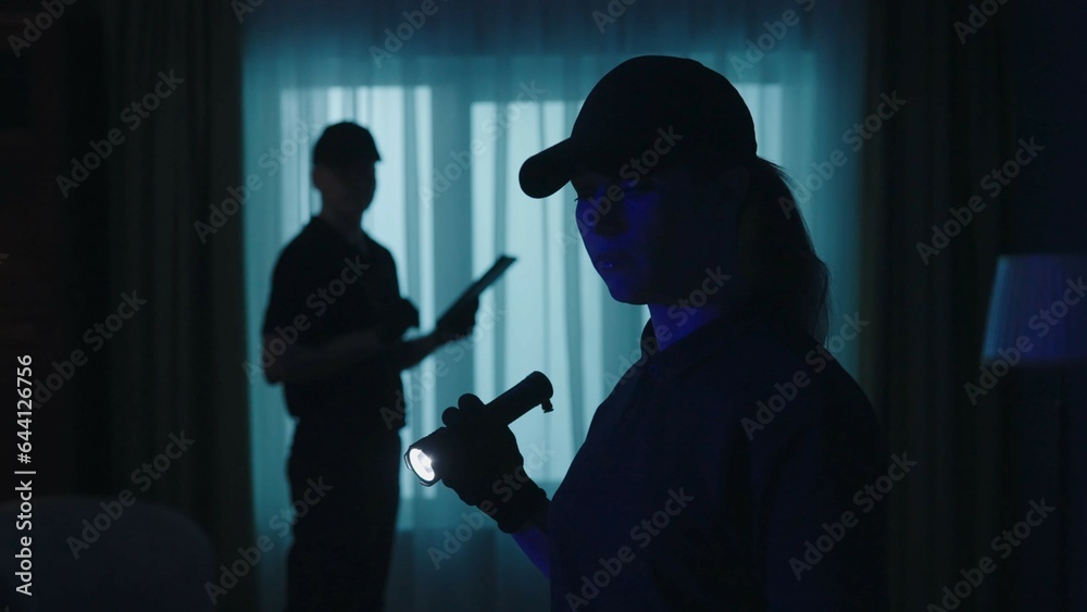 Closeup shot of police officers in uniform standing in the dark room. Crime scene creative concept.