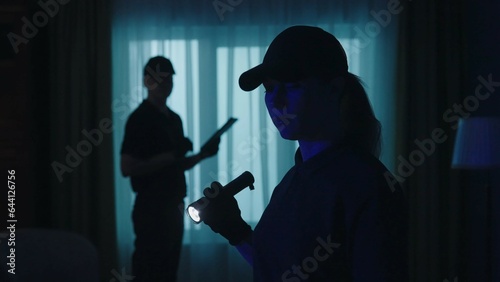 Closeup shot of police officers in uniform standing in the dark room. Crime scene creative concept.