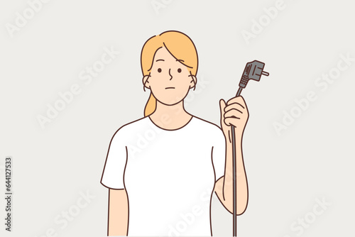 Woman is holding cord from electrical equipment with euro socket due to lack of electricity
