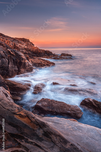 Sunrise long exposure of the sea on the rocks in front of Castello Boccale, Livorno, Tuscany 