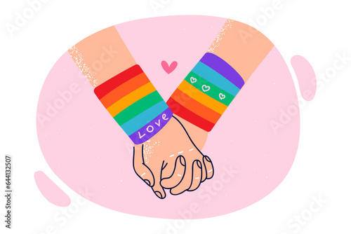 Hands of LGBT lovers in rainbow bracelets, for concept problems tolerance towards gays and lesbians