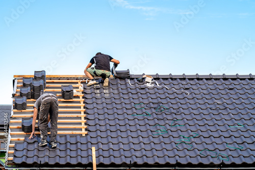 Bild auf Leinwand craftsman builds a new roof from ceramic tiles