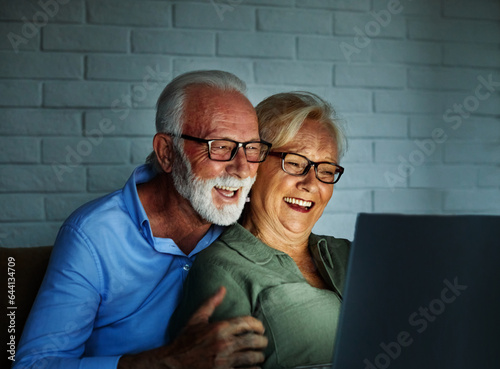 television watching couple laptop night computer home evening elderly senior mature active old woman man movie entertainment fun love together glowing screen