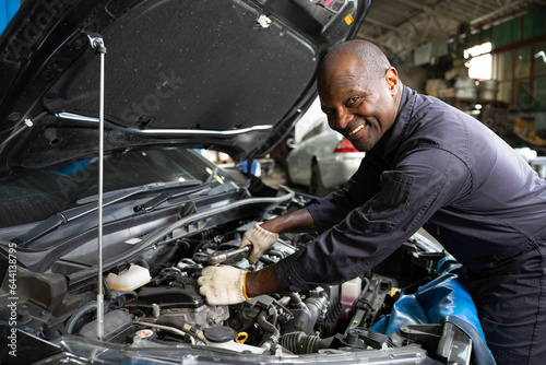 African mechanic worker checking and fixing a car in garage