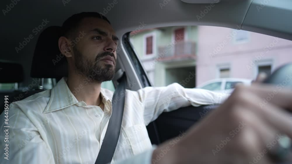 One pensive young Arab man driving car. Interior shot of a Middle Eastern person holding steering wheel with thoughtful carefree expression One pensive young Arab man driving car. Interior shot of a Middle Eastern person holding steering wheel with thoughtful carefree expression