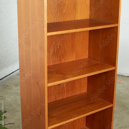 Mid-Century Modern teak bookcase. Minimalist vintage bookshelf. Interior photograph, close-up detail.
