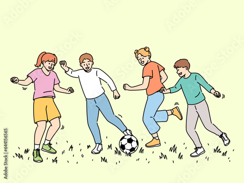 Happy children play football, running on sunny lawn and kicking football ball. Cheerful boys and girls enjoy summer holidays participating in soccer tournament for elementary school students