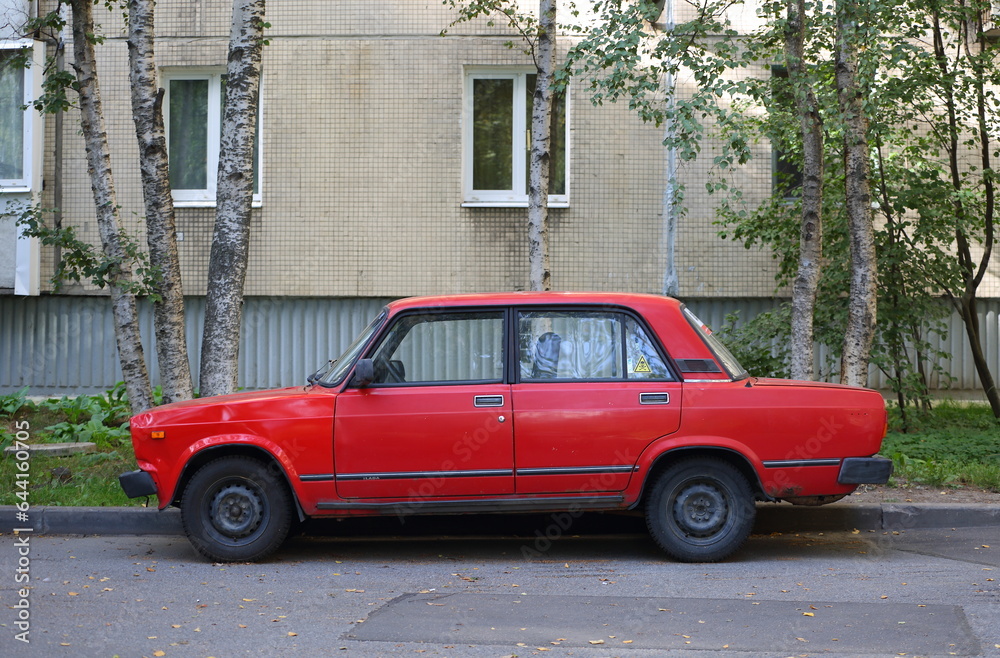 An old red Soviet car in the courtyard of a residential building, Podvoysky Street, Saint Petersburg, Russia, September 05, 2023