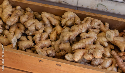 Fresh ginger root in wooden box at market store.