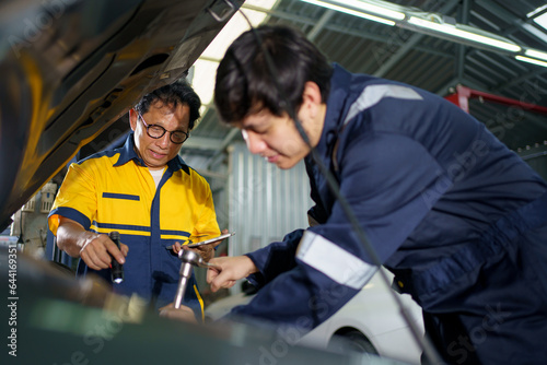 Team of vehicle technicians checking and measuring a vehicle oil engine or engine lubricant level by using oil stick indicator.