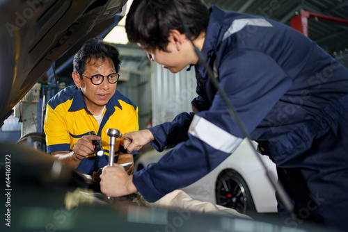 Team of vehicle technicians checking and measuring a vehicle oil engine or engine lubricant level by using oil stick indicator.