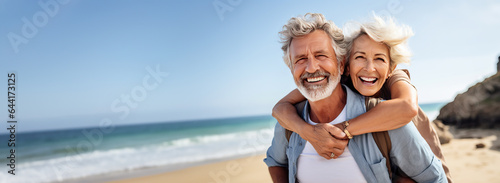 Happy senior couple on a tropical beach in the summer, woman is piggybacking on her husband. Concept of retirement and traveling when you are mature. Shallow field of view with copy space. 