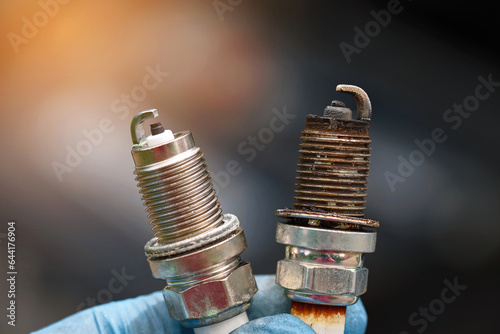 Obraz na płótnie Spark plugs compare, new and old copper spark plugs. Spark plugs with worn electrodes and new one. Selective focus. Electrical ignition parts of gasoline engine. w salonie