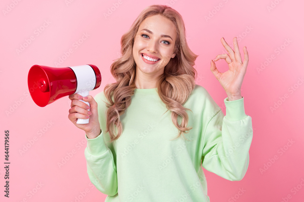 Photo of cheerful pretty girl beaming smile hold loudspeaker demonstrate okey symbol isolated on pink color background Photo of cheerful pretty girl beaming smile hold loudspeaker demonstrate okey symbol isolated on pink color background