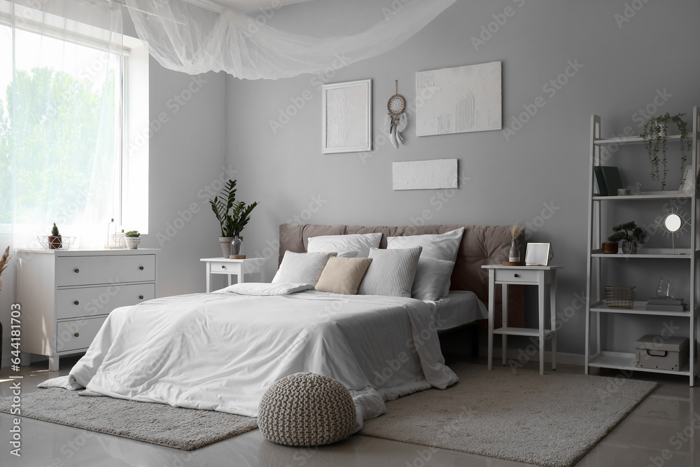Fototapeta premium Interior of light bedroom with dream catcher and paintings on wall