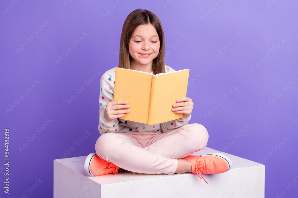 Photo of pretty adorable small girl wear dotted sweater reading fairytale isolated violet color background Photo of pretty adorable small girl wear dotted sweater reading fairytale isolated violet color background