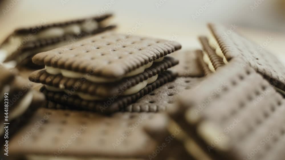 Triple chocolate biscuits with white filling are rotated on a turntable. Close-up. Triple chocolate biscuits with white filling are rotated on a turntable. Close-up.