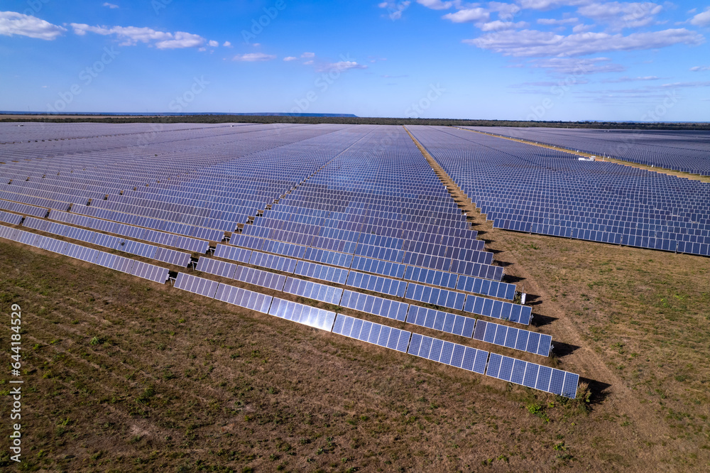 Aerial view of solar panels at a modern solar power plant that generates renewable electricity on a sunny summer day in the Cerrado of Brazil. Concept of ecology, environment, sustainability.