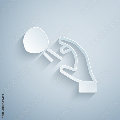 Paper cut Hooligan shooting small stones icon isolated on grey background. Demonstrator. Paper art style. Vector
