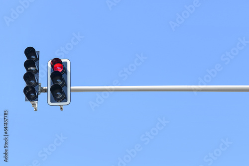 View of red traffic light against blue sky