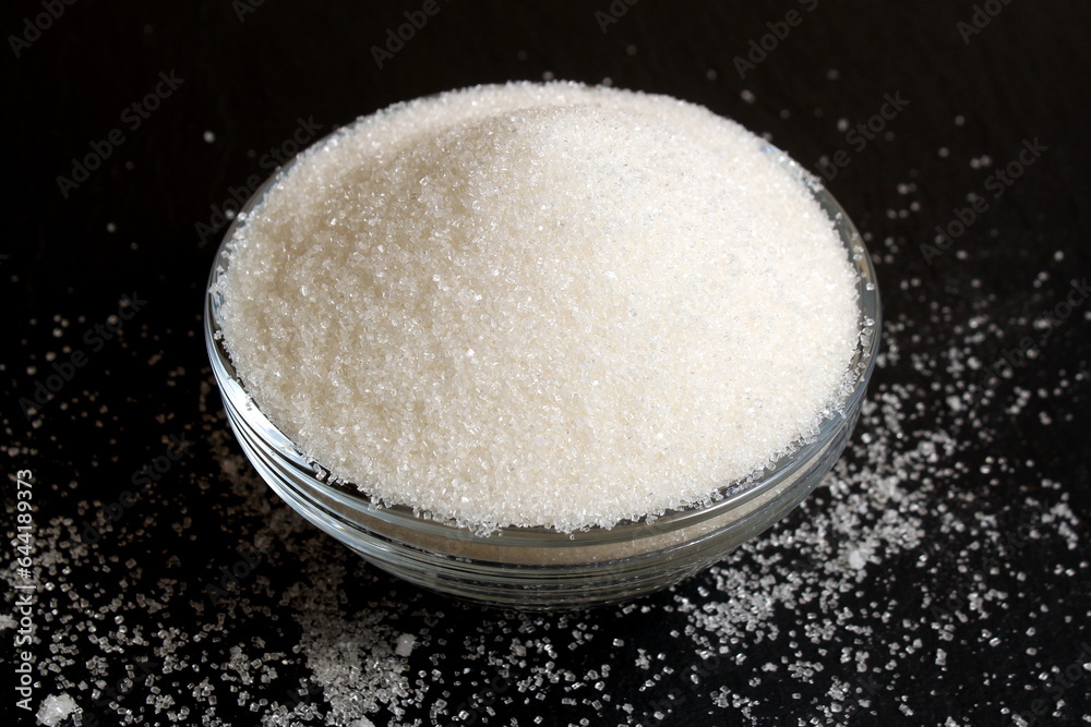 Loose sugar lies in a glass bowl. Loose sugar lies in a glass bowl.