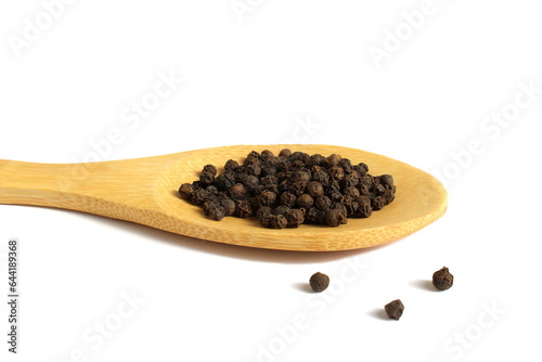  On a white background lies a wooden spoon with seasoning black peppercorns.