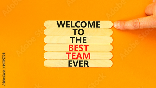 Welcome to best team symbol. Concept words Welcome to the best team ever on wooden stick on beautiful orange background. Businessman hand. Business, motivational and welcome to best team concept. photo