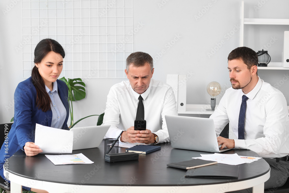 Business consultants working at table in office Business consultants working at table in office