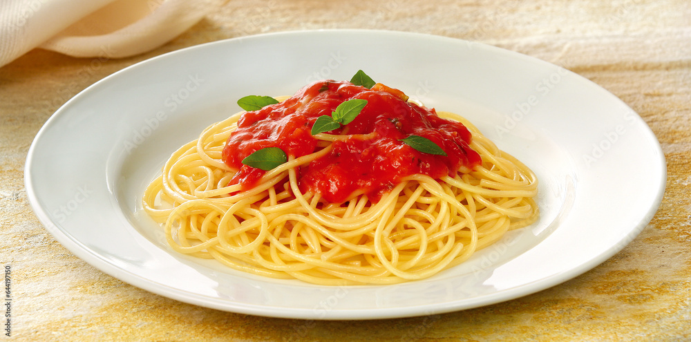 prato com delicioso espaguete com molho de tomate acompanhado com folhas de manjericão prato com delicioso espaguete com molho de tomate acompanhado com folhas de manjericão