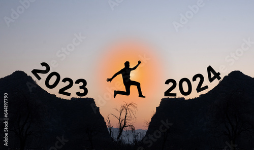 Person jumping from 2023 to 2024 happy new year concept photo