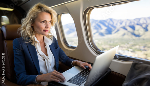 A high-achieving female executive taps into her laptop while aboard a luxurious private jet, symbolizing the pinnacle of corporate success and elite lifestyle. © InputUX