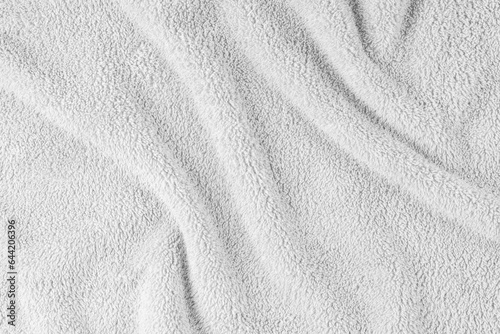 Terry cloth, white towel texture background. Wrinkled and crumped soft fluffy textile bath or beach towel material. Top view, close up.