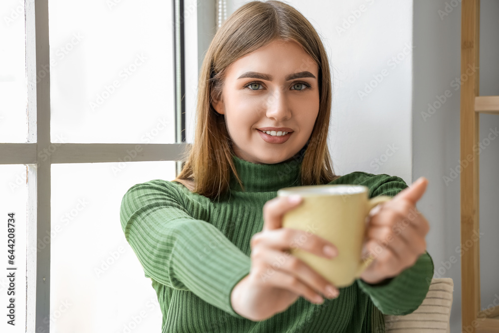 Young woman with cup of hot tea at home, closeup Young woman with cup of hot tea at home, closeup