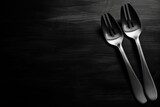 Two forks on a black table, top view copyspace