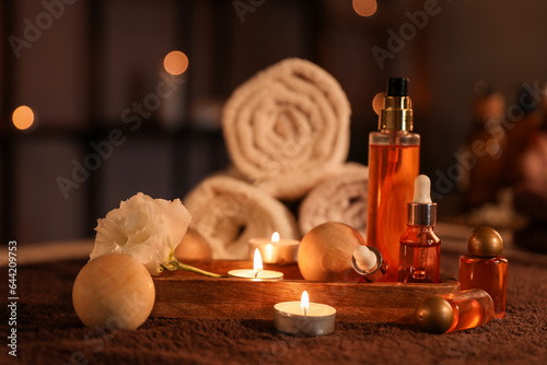 Spa composition with burning candles on table in dark salon  closeup