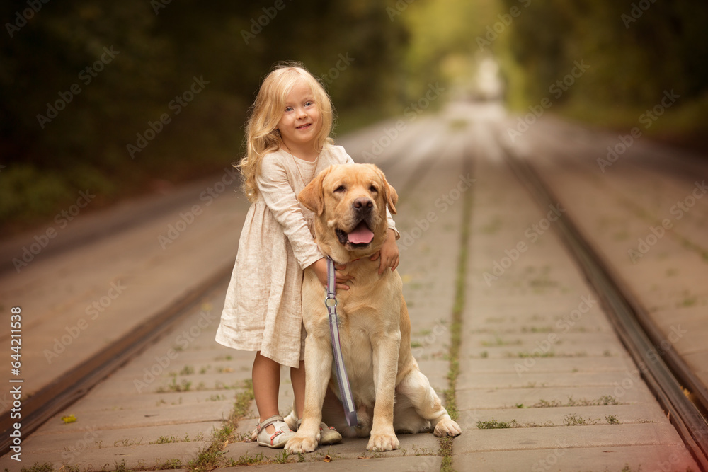 Little girl with white hair with dogs in the park in autumn Little girl with white hair with dogs in the park in autumn