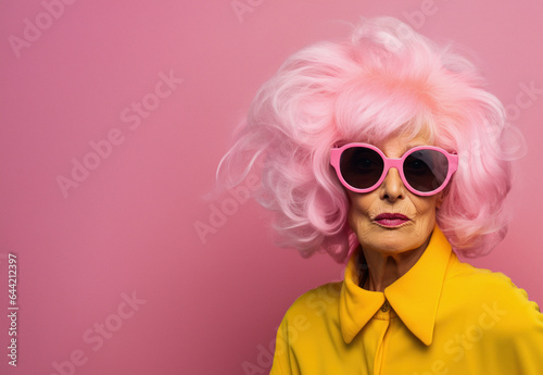Close-up photo of an amazing charming European pink curly haired old woman  Pink hair and yellow dress with pink sunglasses  poster banner header with copy space