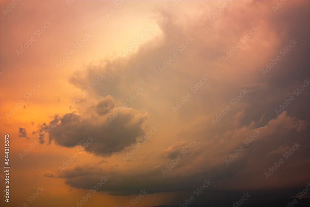 Photo of rainy clouds and orange sky.