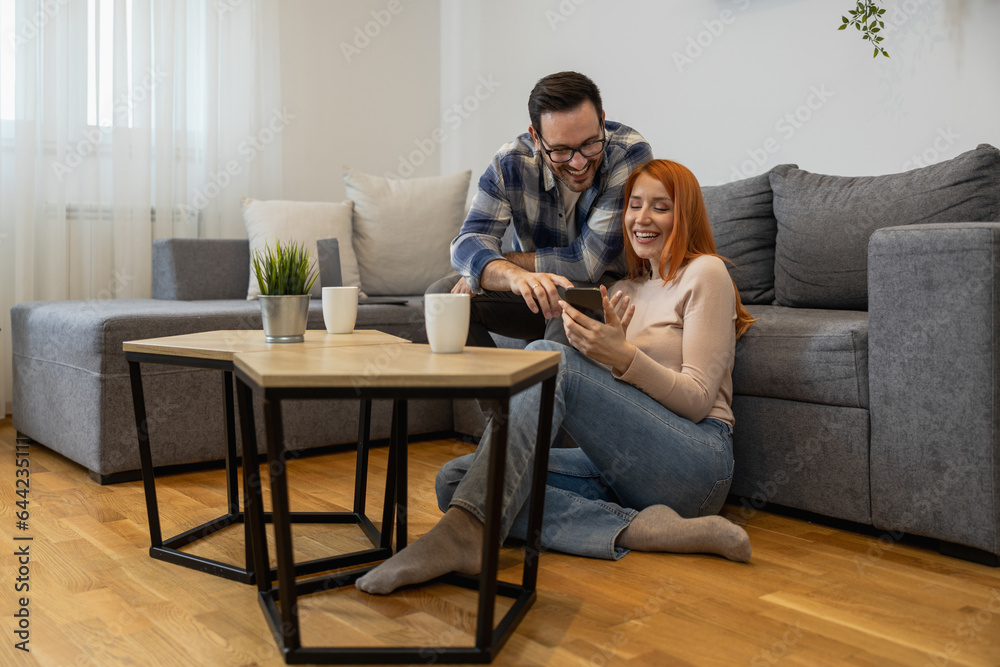 Happy young woman and man using smartphone