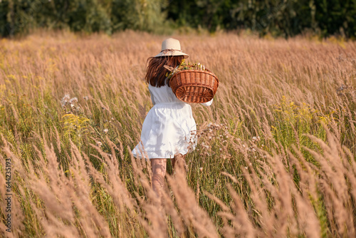Golden Hour: Woman in White Dress Harvesting Herbs in Meadow
