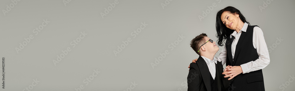schoolboy with down syndrome holding hands with happy mother in formal wear, banner schoolboy with down syndrome holding hands with happy mother in formal wear, banner