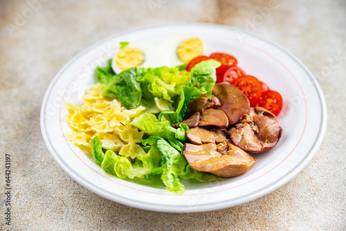 salad chicken liver, pasta, tomato, green leaf lettuce, boiled egg, farfalle snack meal food on the table copy space food background rustic top view