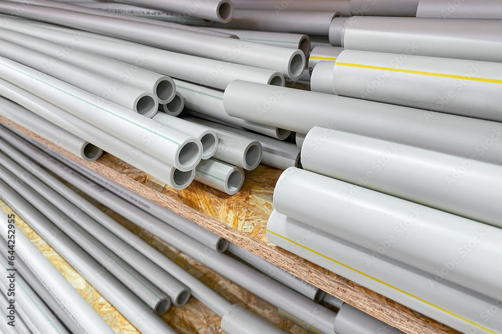 pvc tube pipes stacked for water supply construction material. Warehouse of polypropylene pipes. line of water supply pvc tube pipes stacked for water supply construction material. Warehouse of polypropylene pipes. line of water supply