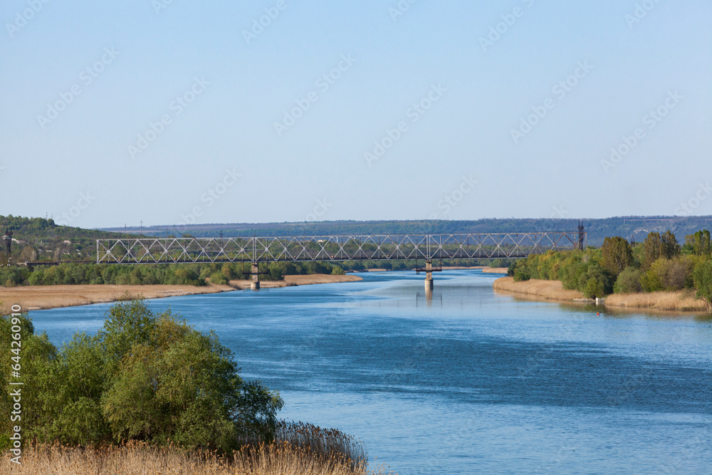 Dniester. View of the river from the railway bridge. The blue sky is reflected in the water.