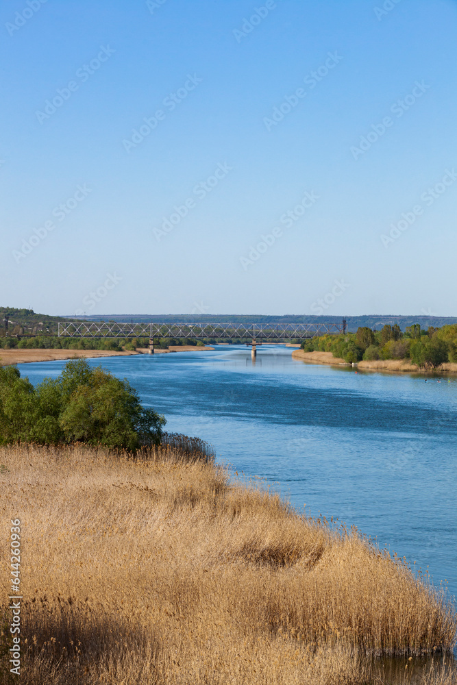 Dniester. View of the river from the railway bridge. The blue sky is reflected in the water.