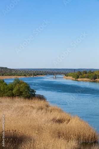 Obraz na płótnie Dniester. View of the river from the railway bridge. The blue sky is reflected in the water. w salonie