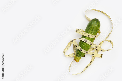Zucchini with measuring tape on white background