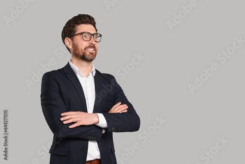 Happy real estate agent in glasses on grey background. Space for text