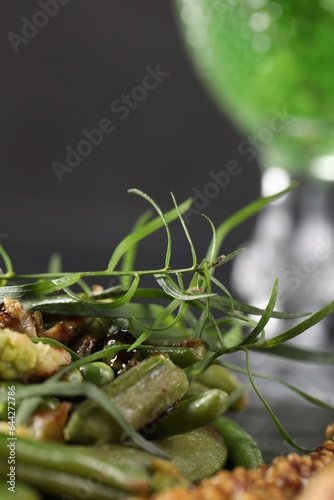 Delicious tarragon and baked vegetables on table, closeup. Space for text